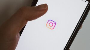 Smartphone affichant le logo Instagram tenu en main